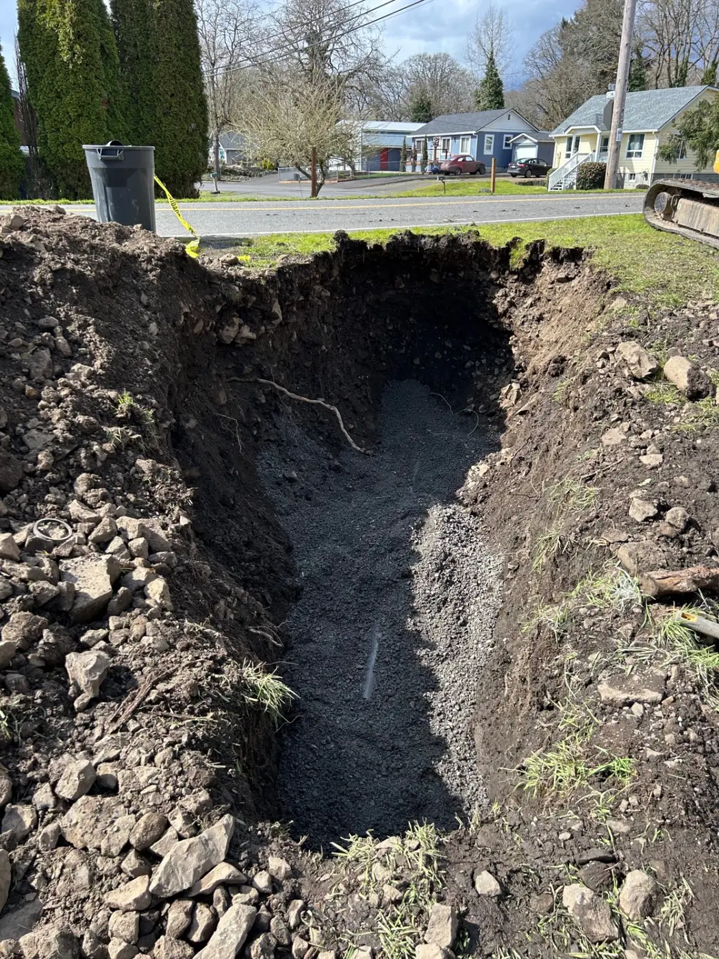 Deep curbside sewer trench excavation and backfill by Wild Pine Plumbing in a Portland, Oregon neighborhood