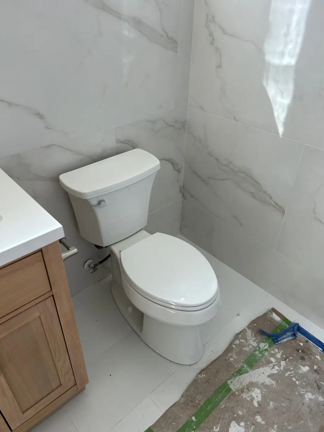 Marble-look tile bathroom with Toto toilet and oak shaker vanity installed by Wild Pine Plumbing in Portland, Oregon