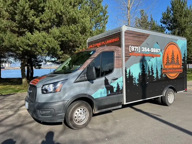 Wild Pine Plumbing branded box truck parked along the Columbia River in St Helens, Oregon
